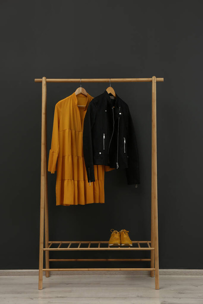 Rack with stylish clothes near black wall - Foto, immagini