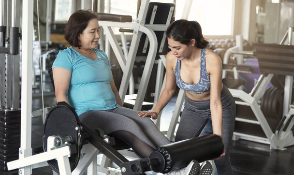 Spor salonunda halter kaldırma Asyalı kadın kıdemli eğitmen. sağlıklı yaşam tarzı ve egzersiz kavramı. - Fotoğraf, Görsel