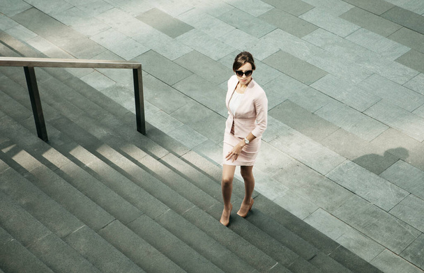 Young woman dressed in business style next to the stairs, business and career concept - Valokuva, kuva