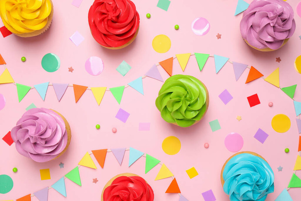 Colorful birthday cupcakes on light pink background, flat lay - Фото, изображение