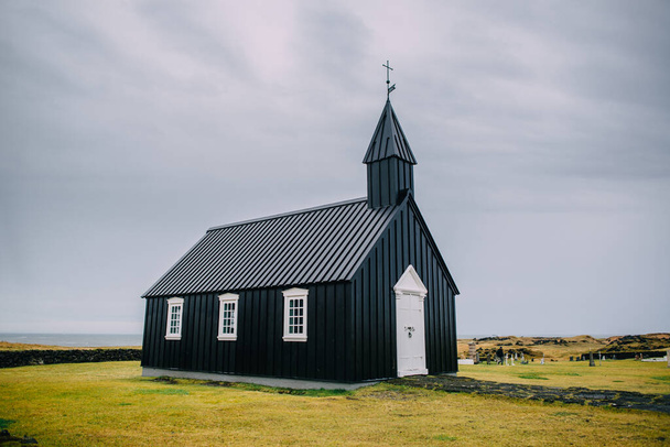 Icelandic landscape with a black church. - Foto, afbeelding