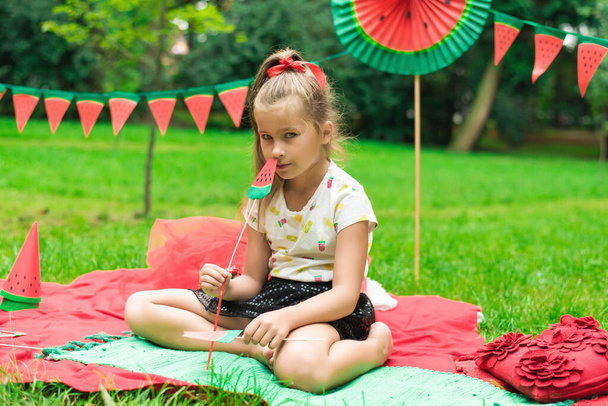Görögdinnyés buli, piknik gyerekeknek a parkban. Görögdinnye nap. Cuki kislány.. - Fotó, kép