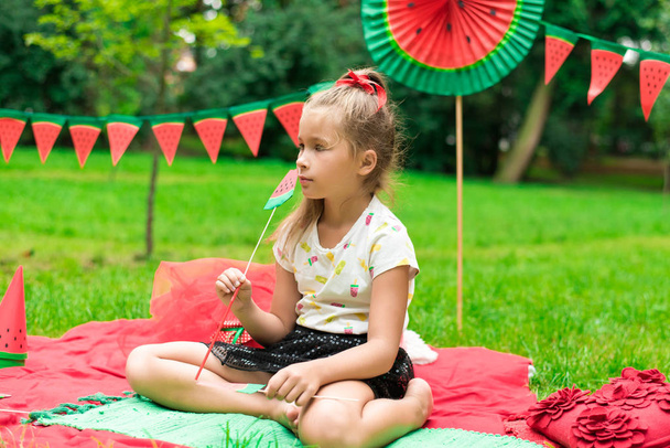 Watermeloen feest, picknick voor kinderen in het park. Watermeloen dag. Leuk klein meisje. - Foto, afbeelding