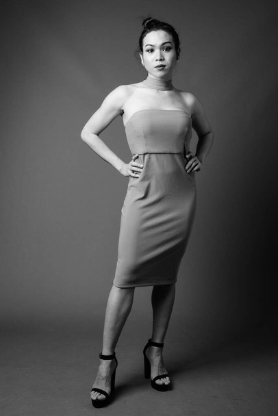 Studio plan de jeune belle femme transgenre asiatique sur fond gris en noir et blanc
 - Photo, image