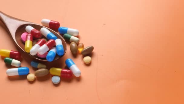 Multi kleurrijke pillen en capsule op lepel op kleur achtergrond  - Video