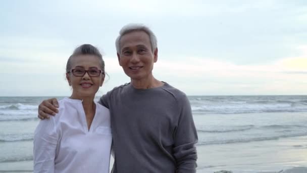 Ασιατικό ζευγάρι ηλικιωμένων αναζητούν κάμερα closeup ηλιοβασίλεμα παραλία μήνα του μέλιτος οικογένεια μαζί ευτυχία άνθρωποι τρόπο ζωής, Αργή κίνηση πλάνα - Πλάνα, βίντεο