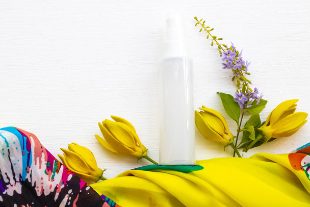 collagen water spray beauty health care for skin face with yellow flower ylang ylang ,yellow scarf of lifestyle woman relax arrangement flat lay style on backround white  - Photo, Image