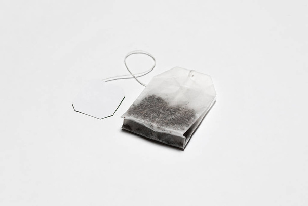 Zbliżenie Tea Bag Mockup z etykietą izolowane na białym tle. Jednorazowa torebka herbaty. Zdjęcie wysokiej rozdzielczości. - Zdjęcie, obraz
