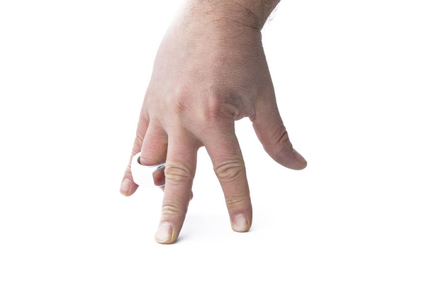 Die menschliche Hand am Ringfinger ist wie ein Ehering gekleidet. Nahaufnahme. isoliert auf weißem Hintergrund - Foto, Bild