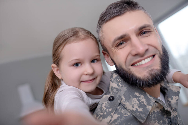 Dad military and little daughter are happy together. - Foto, afbeelding