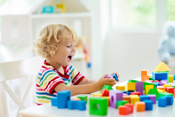 Kinderspielzeug. Kind baut Turm aus Spielzeugklötzen. - Foto, Bild