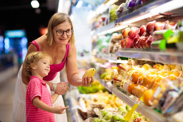 Äiti ja lapsi ostaa hedelmiä supermarketista
. - Valokuva, kuva