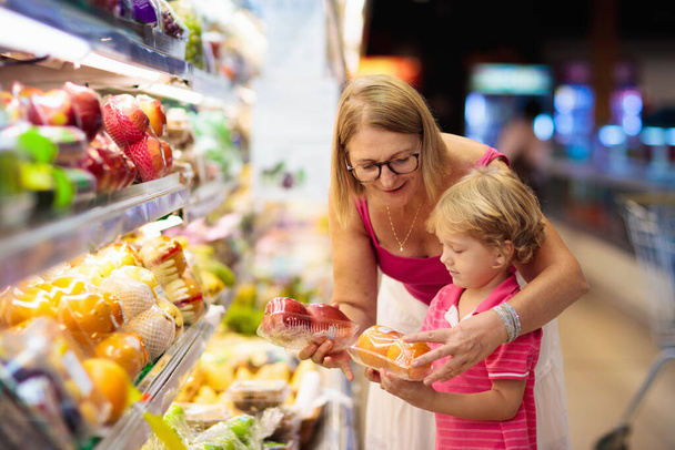 Mother and child buying fruit in supermarket. - Valokuva, kuva