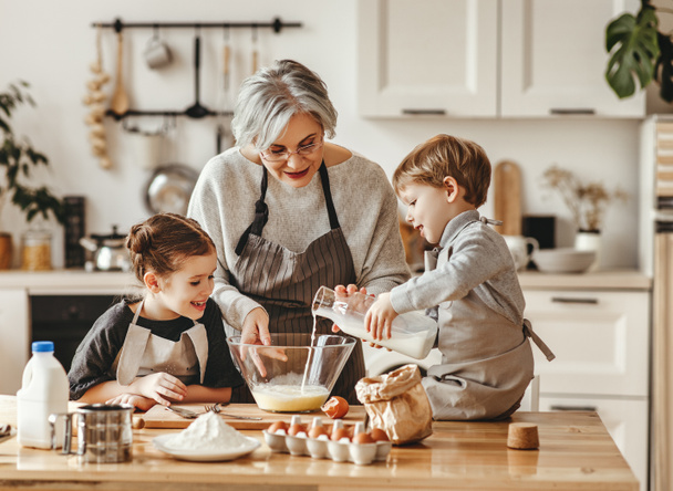 ευτυχισμένη οικογένεια γιαγιά και εγγόνια μαγειρεύουν στην κουζίνα,  - Φωτογραφία, εικόνα