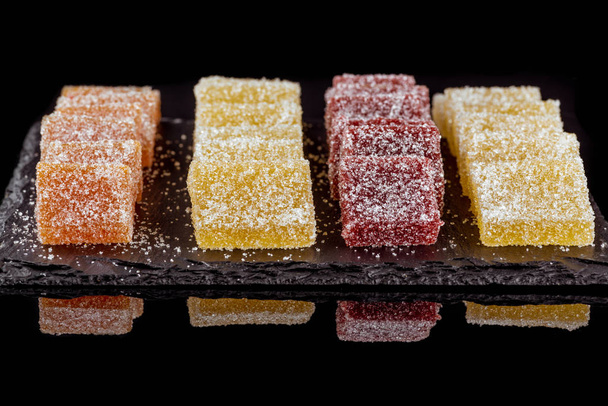 Slices of beautiful delicious fruit marmalade of various colors. Black background. Close-up. - Fotoğraf, Görsel