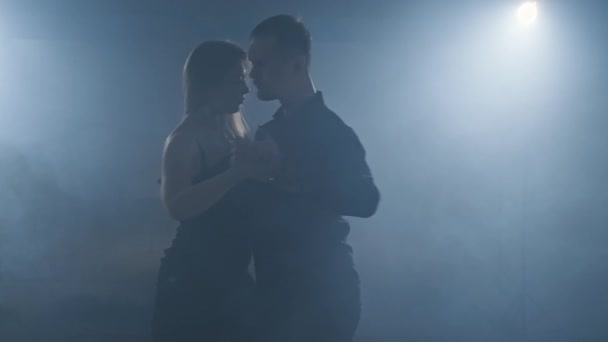 Graceful latinamerican dance performed by young couple in smoky ballroom. - Felvétel, videó