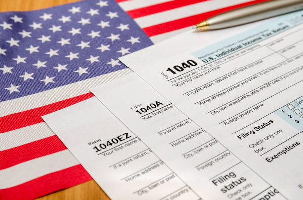 1040 φορολογική δήλωση με στυλό και αμερικανική σημαία - Φωτογραφία, εικόνα
