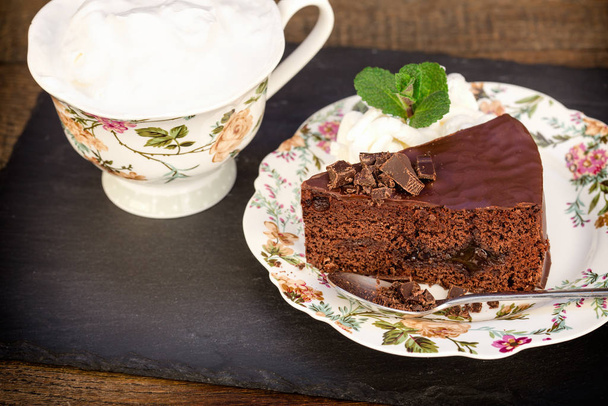 Pastel de chocolate cremoso con mermelada de albaricoque y café en la mesa
 - Foto, Imagen