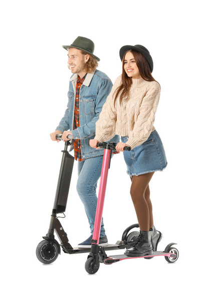 Young couple with kick scooters on white background - Photo, Image