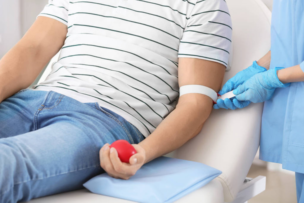 Doctora preparando donante masculino para transfusión de sangre en el hospital
 - Foto, imagen