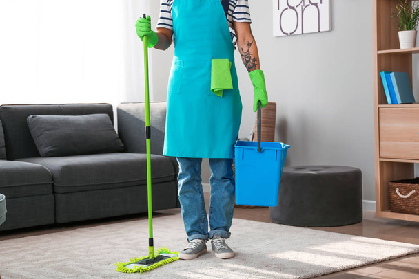 Joven asiático hombre con artículos de limpieza en casa
 - Foto, Imagen