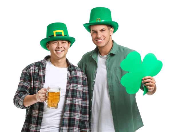 Young men with beer and clover on white background. St. Patrick's Day celebration - Photo, Image
