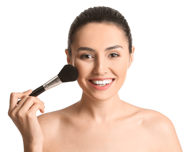 Beautiful young woman with makeup brush on white background - Φωτογραφία, εικόνα