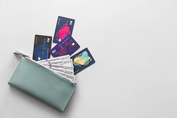 Portemonnee met creditcards en geld op lichte achtergrond - Foto, afbeelding