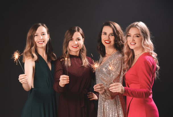 Красиві молоді жінки з різдвяними блискітками на темному тлі
 - Фото, зображення