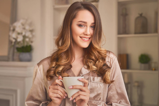 Sensitive young woman delights her morning coffee. - Fotó, kép