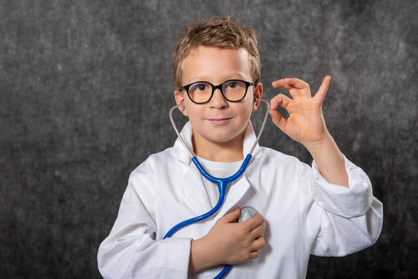Lindo niño niño desgaste médico uniforme jugando doctor, retrato - Foto, imagen