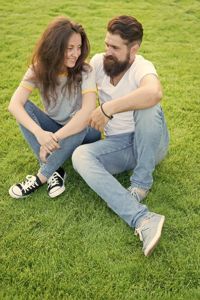 Couple in love relaxing on green lawn. Lovely couple outdoors. Simple happiness. Couple relations goals. Couple spend time in nature. Playful girlfriend and boyfriend dating. Summer vacation - Фото, изображение