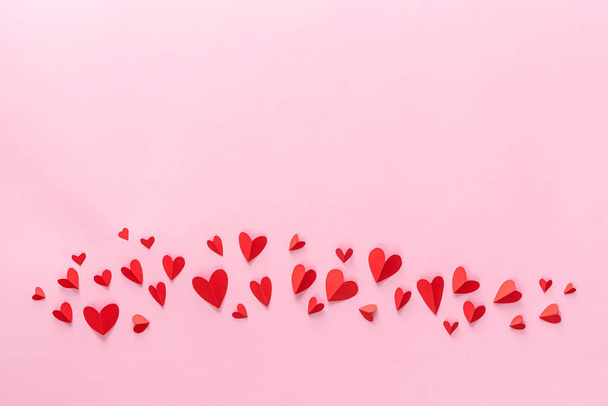 День Святого Валентина. Красные бумажные сердца изолированы от розовых
. - Фото, изображение