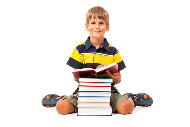 Schoolboy is sitting on books - Φωτογραφία, εικόνα