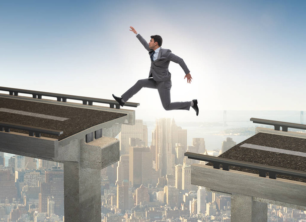 Νεαρός επιχειρηματίας πηδάει πάνω από τη γέφυρα - Φωτογραφία, εικόνα