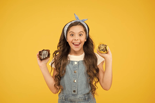 Yummy cupcakes. Bakery and confectionery concept. Kid girl hold glazed muffins. Delicious cupcakes. Happy childhood. Adorable smiling child with cupcakes on yellow background. Cafe restaurant food - Zdjęcie, obraz