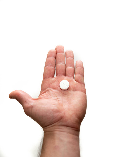 big white pill in hand on a white background - Foto, imagen