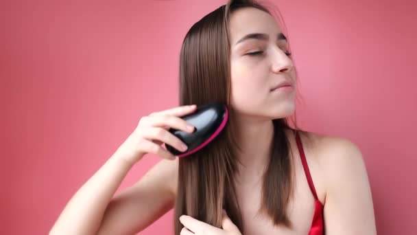 Young beautiful girl having problems while hair on pink background - Πλάνα, βίντεο