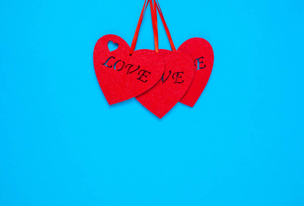 Three decorative heart with the inscription love on a blue background - Photo, Image