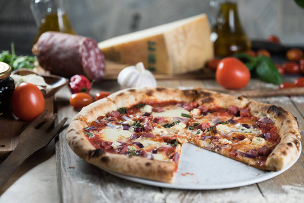 Pizza fraîche cuite au four sur table en bois avec ingrédients
 - Photo, image