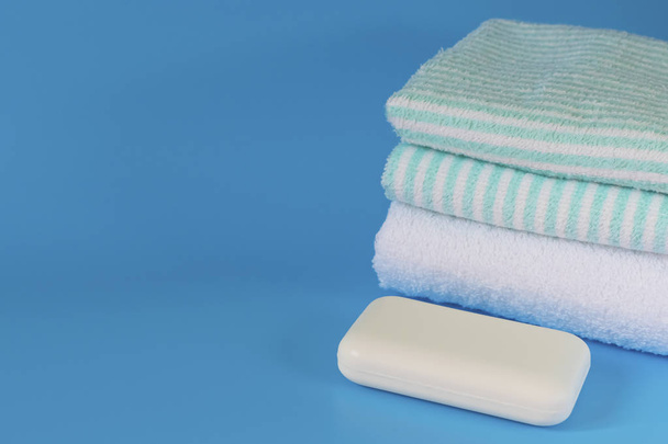 青を基調とした柔らかくてふわふわのタオル。バス、ランドリー、ボディケアのための石鹸。衛生用品だ浴室の付属品. - 写真・画像