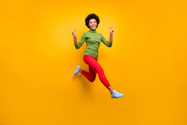 Full length body size view of her she nice attractive lovely cheerful cheery wavy-haired girl jumping showing v-sign having fun isolated over bright vivid shine vibrant yellow color background - Foto, immagini