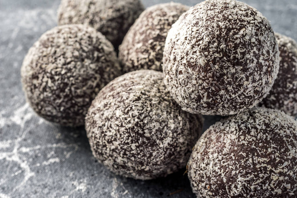 Zelfgemaakte gezonde proteïne energie ballen in een kokoskom met gedroogde abrikozen, rozijnen, walnoten, amandelen en kokos. Gezond zoet voedsel. - Foto, afbeelding