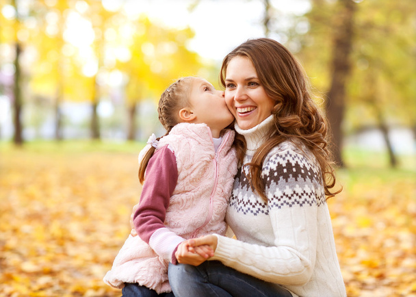 Mother and daughter having fun in the autumn park - Фото, изображение