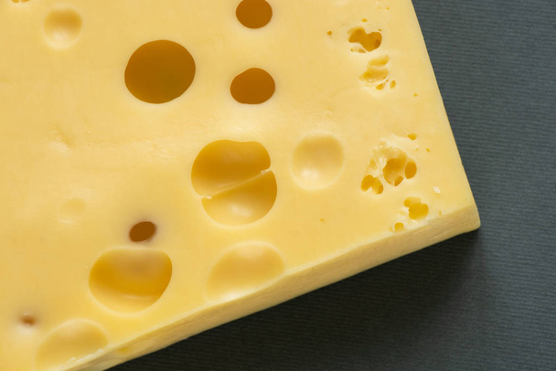 pedaço de queijo em um fundo cinza
 - Foto, Imagem