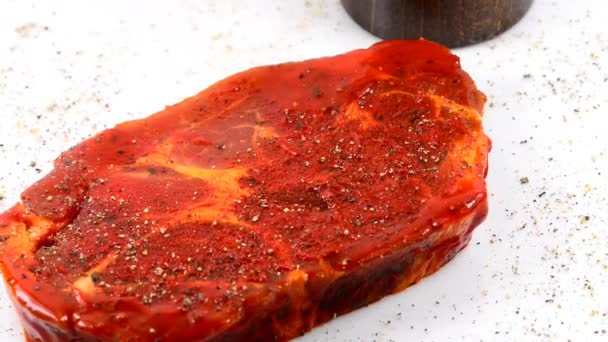 raw and marinated pork neck on a turn table with pepper mill - Footage, Video