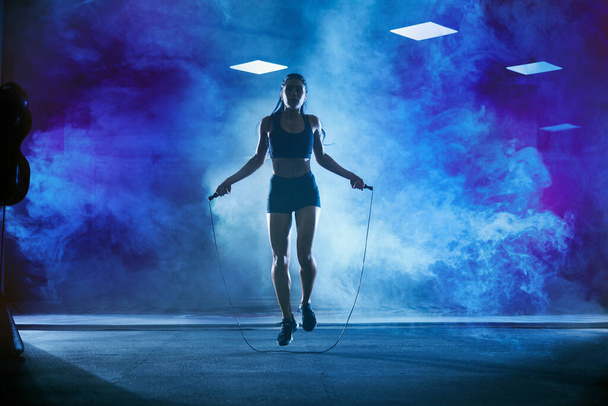 Athletic woman using skipping rope. - Photo, image