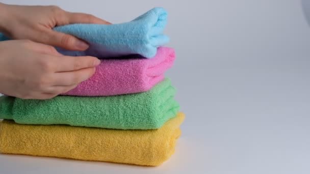 Close-up of hands putting stack of fresh bath towels on the bed sheet. Room service maid cleaning hotel room macro - Footage, Video