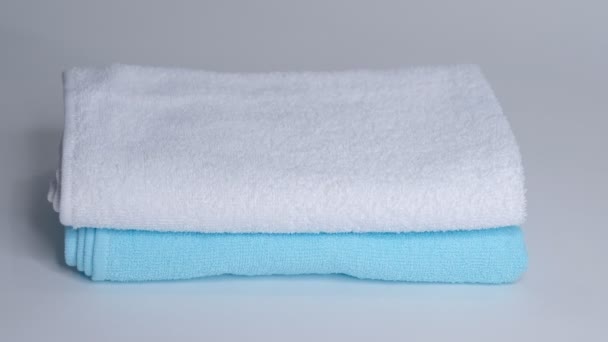 Close-up van de handen zetten stapel verse badhanddoeken op het laken. Roomservice schoonmaakster hotelkamer macro - Video