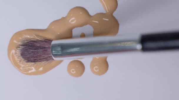 Smears of foundation for face. Cosmetic smear. Isolated on white background. Foundation face make-up smudge, smear. Cosmetic liquid foundation or bb cream beige. Closeup Slow motion. - Footage, Video